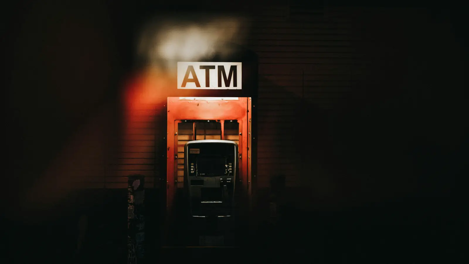 A street ATM lit up at night