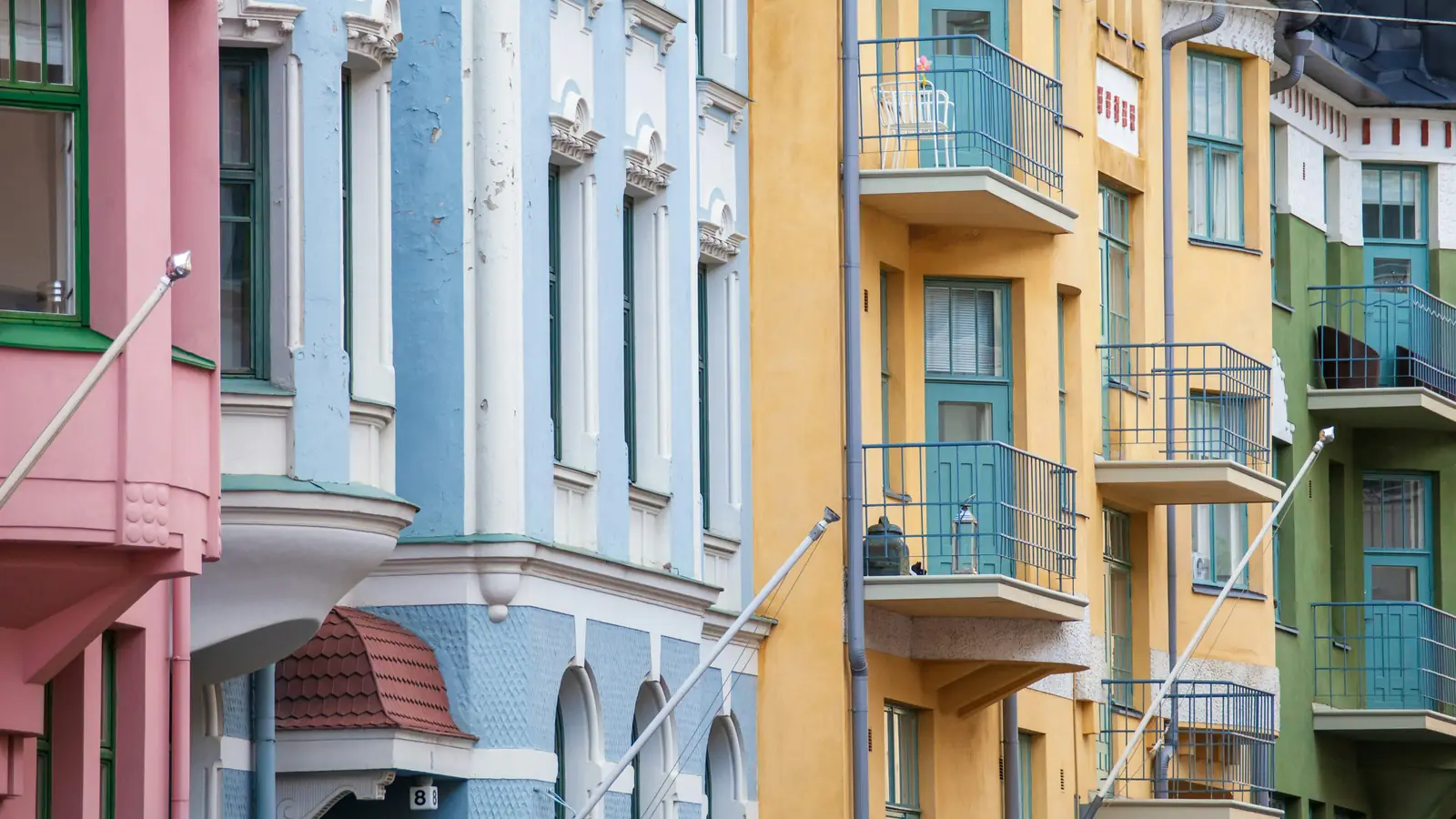Pastel apartment buildings with balconies on a street in Helsinki