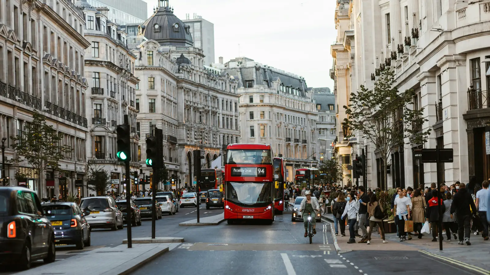 A red double-decker bus on a busy London street
