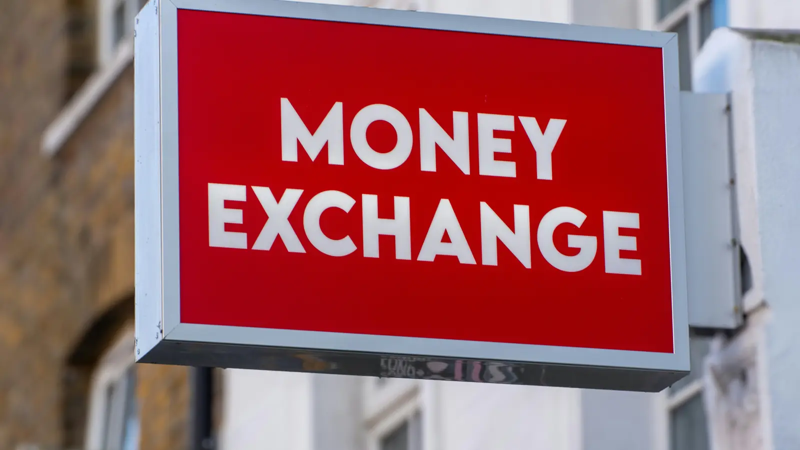 A red “Money exchange” sign on a street